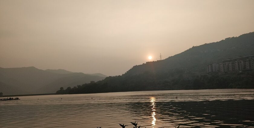 A sunset picture of Lavasa's scenic lake surrounded by lush hills and mountains.