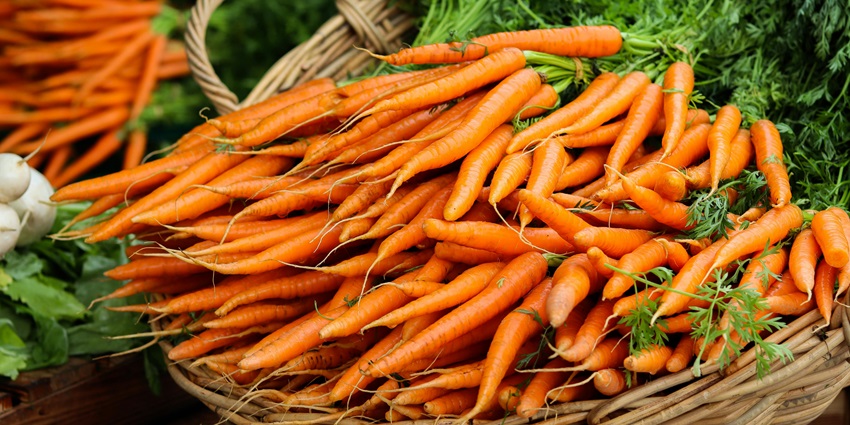 A basket full of carrots on a stall in Laxmipuri Market offering a fresh produce.