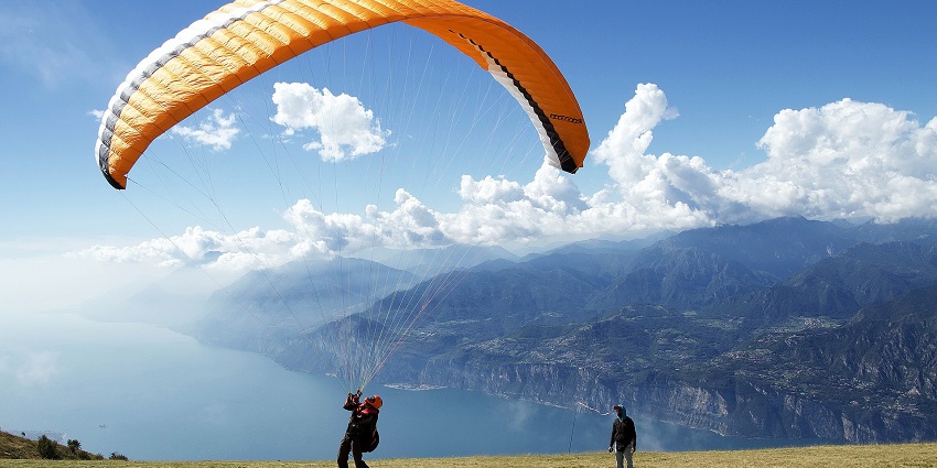 A Paraglider landing on a mountain of Garda Italy with the instructor looking from behind