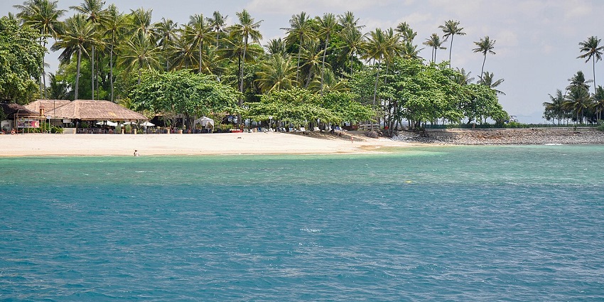 A scenic view of a tropical beach in Gili Islands with crystal-clear turquoise waters