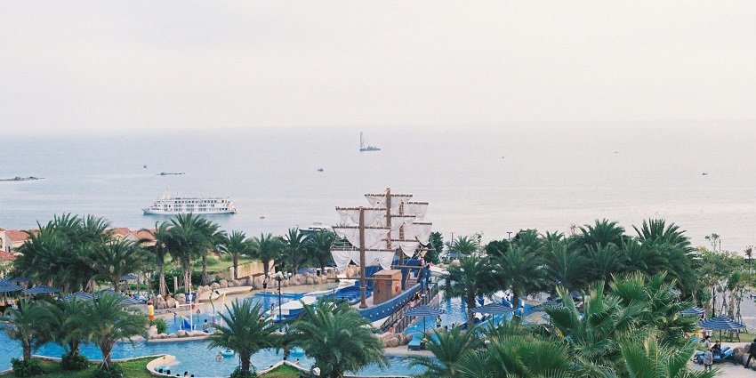 Recreational area featuring swimming pools, palm trees, and a ship, perfect for relaxation and fun in Panseht water park.