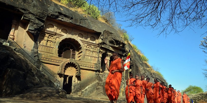 Buddhist monks at the Pandavleni Caves, showcasing ancient rock-cut architecture.