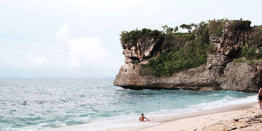 Image of the scenic location of Balangan Beach, surrounded by cliffs and the Indian Ocean.