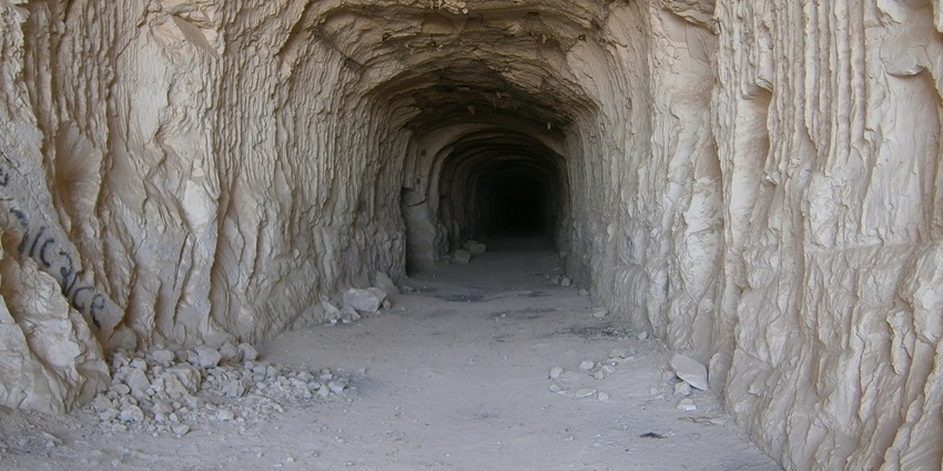 An image of a dimly lit cave tunnel with rugged walls near Maharashtra.