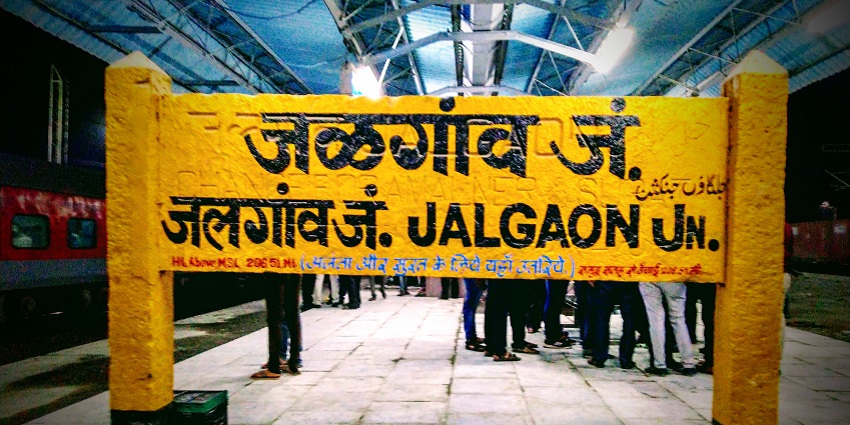 Yellow station board of Jalgaon Junction written in 4 languages on a railway platform