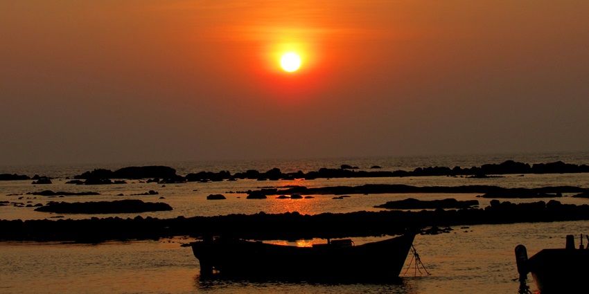 Stunning sunset view at Khanderi Fort, highlighting the landscape and fort structure.