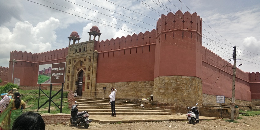 A view of Nagardhan Fort, showcasing its historic architecture and green surroundings under blue skies.