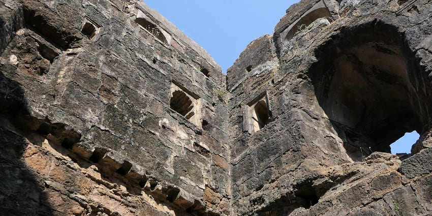 Ancient stone walls of Shirgaon Fort, with a panoramic view of the surrounding landscape