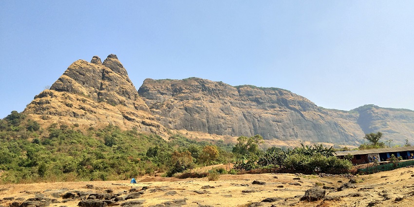 The Calm waters embraced by verdant trees reflect the charm of Prabalgad Fort.
