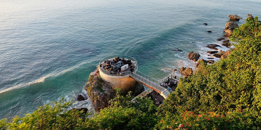 An image of Melasti Beach nestled under towering cliffs in Bali's Bukit Peninsula.