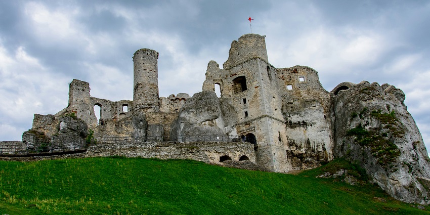 Image of a fort ruins on green grass field under clearing blue sky day time