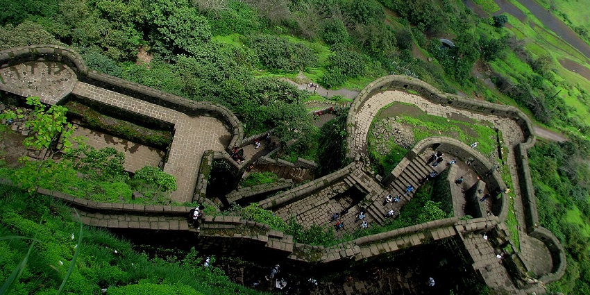 The whole area of the Lohagad Fort is covered in greenery and tourists are visible from above.