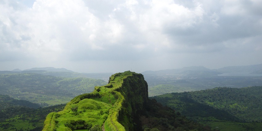 An image of Lohagad Fort with its ancient walls against a backdrop of lush greenery.