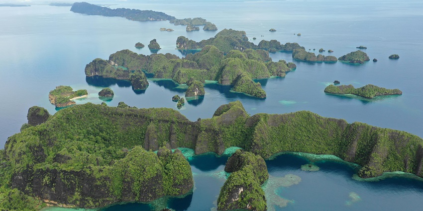 An image of the stunning cliffs surrounding Lombok Island location with clear waters.