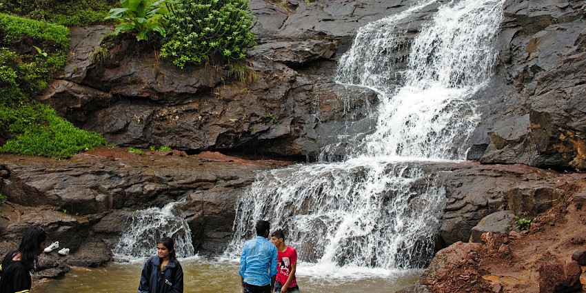 An image of a waterfall with a clear stream flowing between the massive rocks