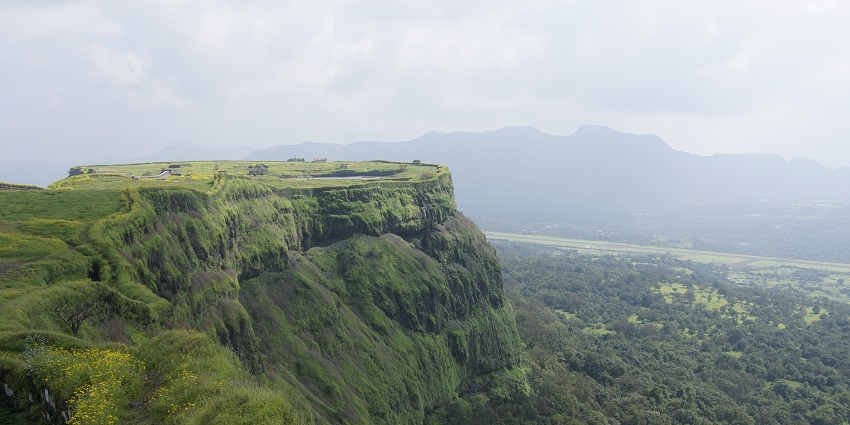 Lush green hills and valleys in Lonavala with mist partially covering the landscape