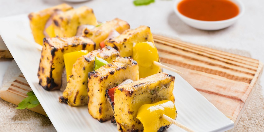 A side view of Sichuan cuisine is presented in a wooden utensil placed on a food table