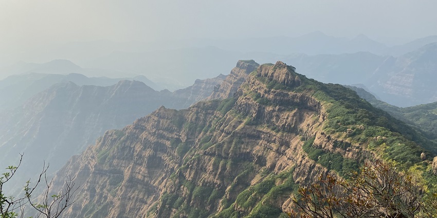 A scenic view from Mahabaleshwar, showcasing lush green hills and a clear blue sky