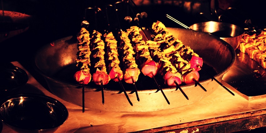 Paneer Tikka, skewered on grill sticks, served on a plate with onions and bell pepper, one of the best food in Nagpur.