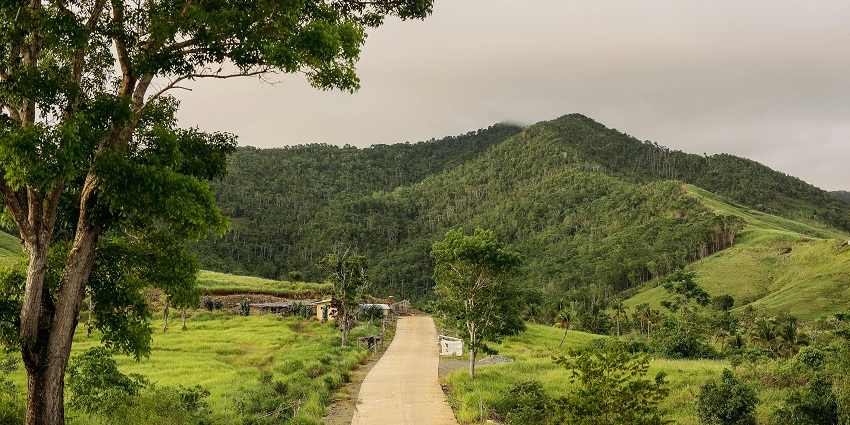 A majestic view of Makalidurga Hill that is surrounded by lush greenery and blue skies.