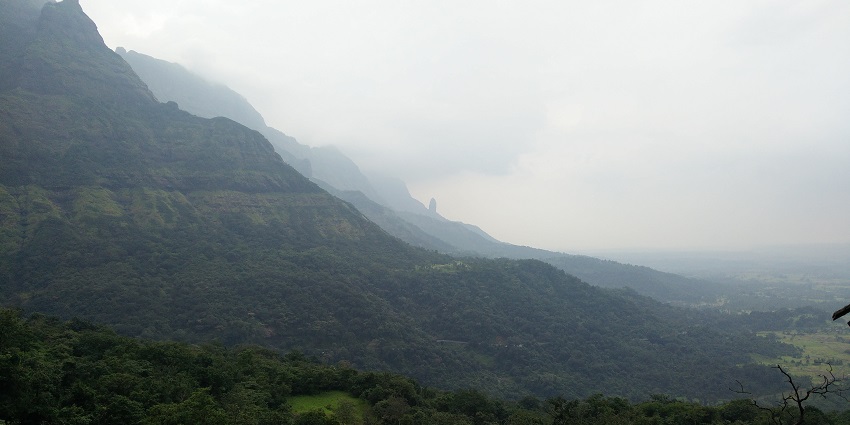 A serene road winding through the misty Malshej Ghat hills in August in Maharashtra