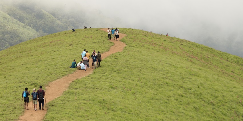 Image of a hill view point where people are strolling around some went some trekking