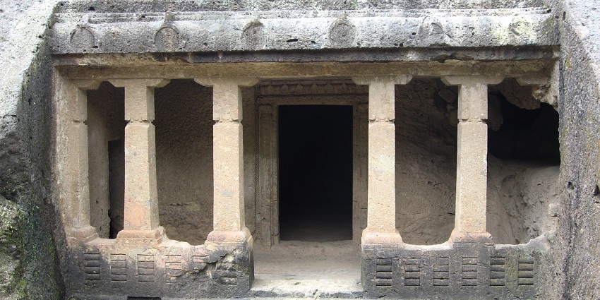 Interior hall of Mandapeshwar Caves featuring intricately carved pillars and sculptures.