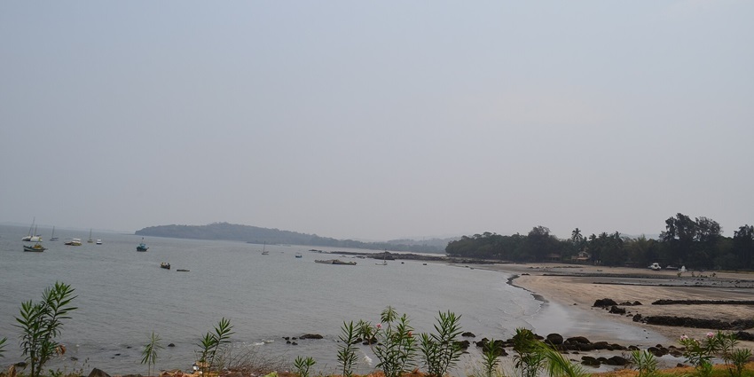 A serene view of Mandwa Beach with soft sands, gentle waves, and a clear blue sky
