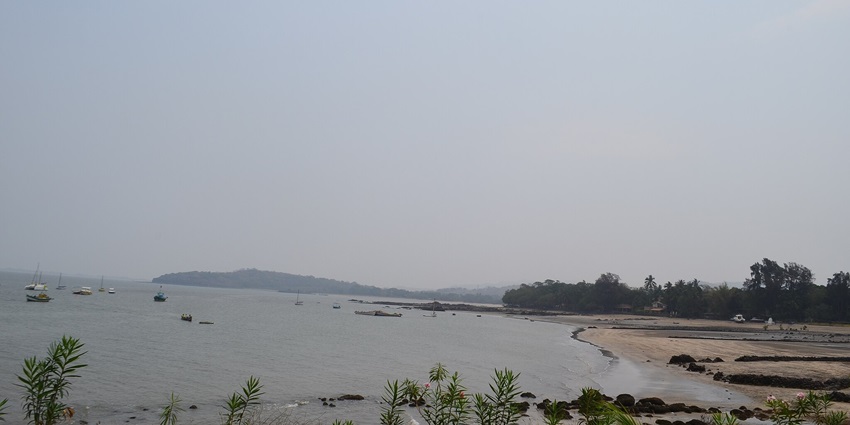 A serene view of Mandwa Beach with soft sands, gentle waves, and a clear blue sky