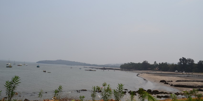 Boats floating at Mandwa Beach with golden sand and gentle waves, offering kayaking in Mumbai.