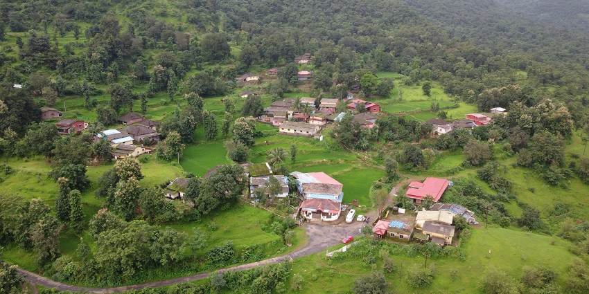 Aerial view of old houses in a lovely village, amidst verdant fields