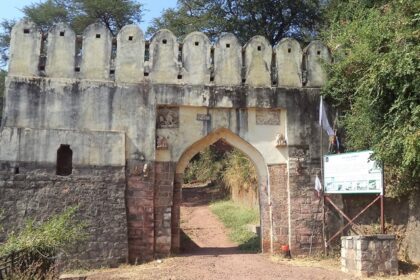 Manikgad Fort lies on a hill in Maharashtra, showing its old ruins and rough landscape.