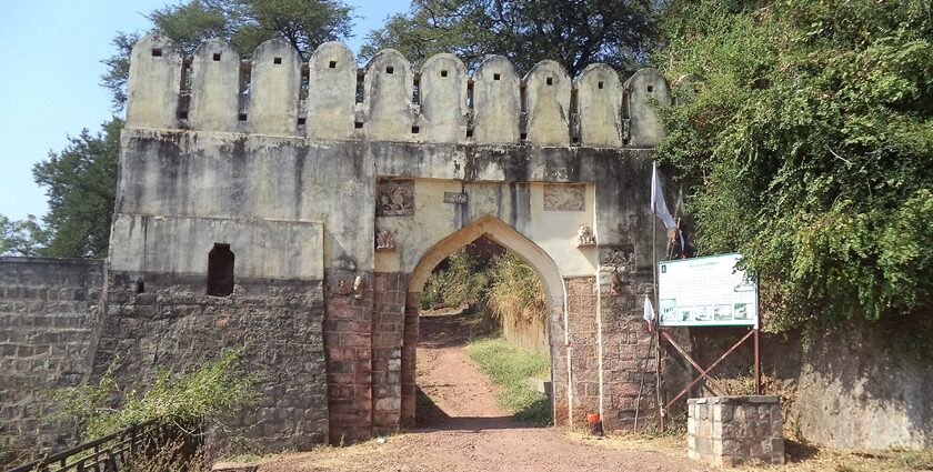 Manikgad Fort lies on a hill in Maharashtra, showing its old ruins and rough landscape.