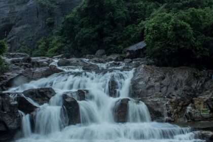 A breathtaking view of Manimuthar Waterfalls cascading down amidst lush greenery.