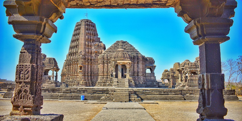 The beautiful facade of a temple situated amongst historical grounds under clear blue skies.