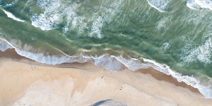 Aerial view of Manki Beach with gentle waves, one of the largest beaches near Honnavar.