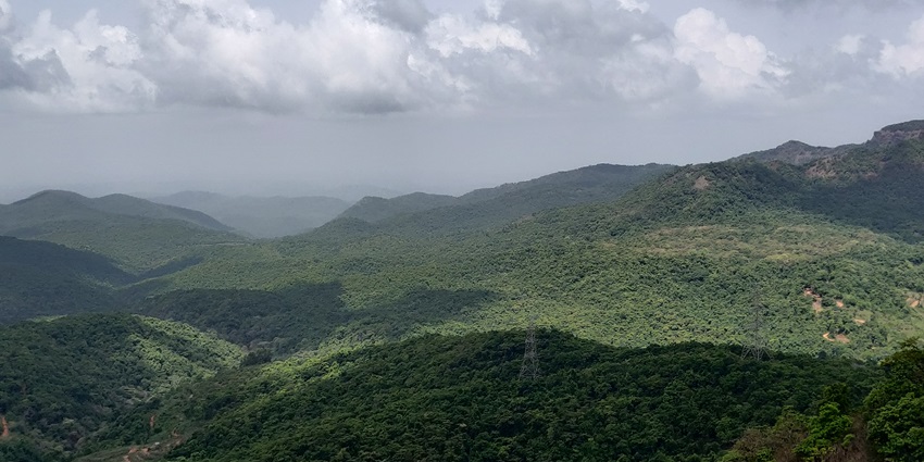 Image of lush green hill surrounded by blue sky in Maharashtra - similar to the Manohar‑Santoshgad Fort
