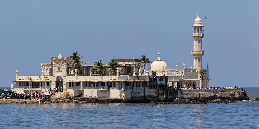 A fantastic view of Haji Ali Dargah in Mumbai, surrounded by water, with the city skyline behind.