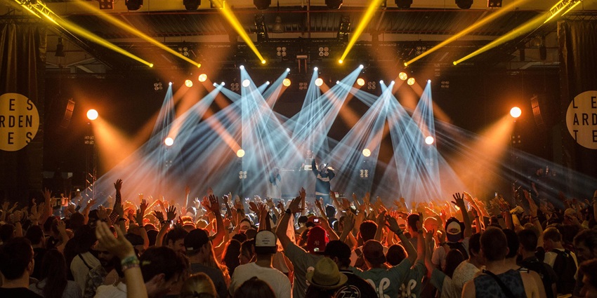 A picture of an electrifying nightclub with vibrant lighting and people dancing around