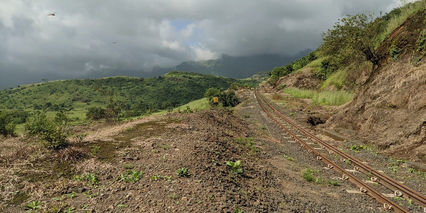 Serene view of mountains covered with lush greenery and visible thick fog at Matheran.