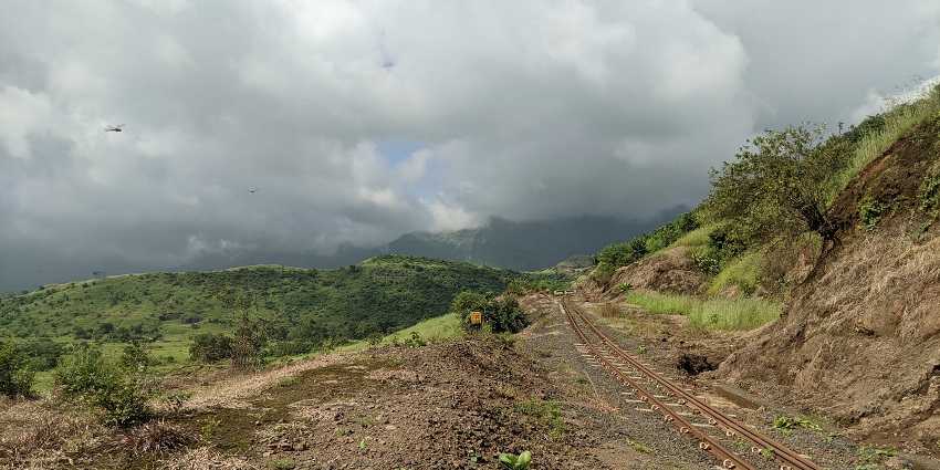 A picture of Matheran hill station with mist-covered forests and a railway track.