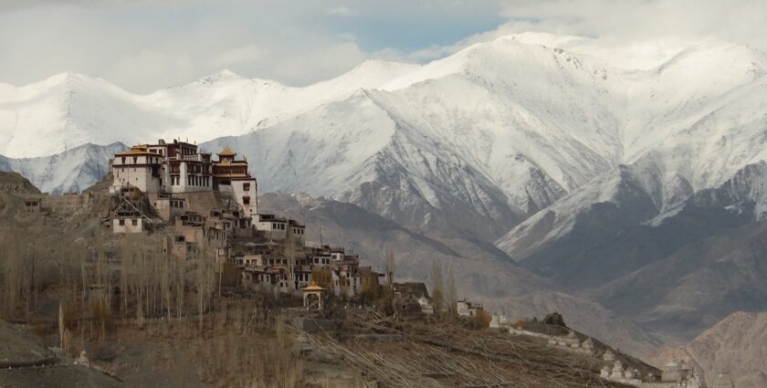 Panoramic view of the Matho monastery with snow covered peaks in the background