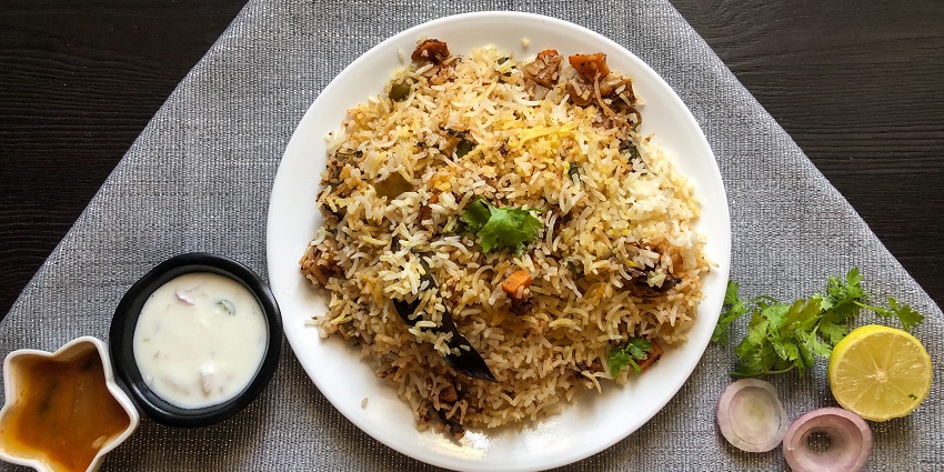 Delicious hyderabad biryani served with onion and lemons, one of the most popular food in Nellore