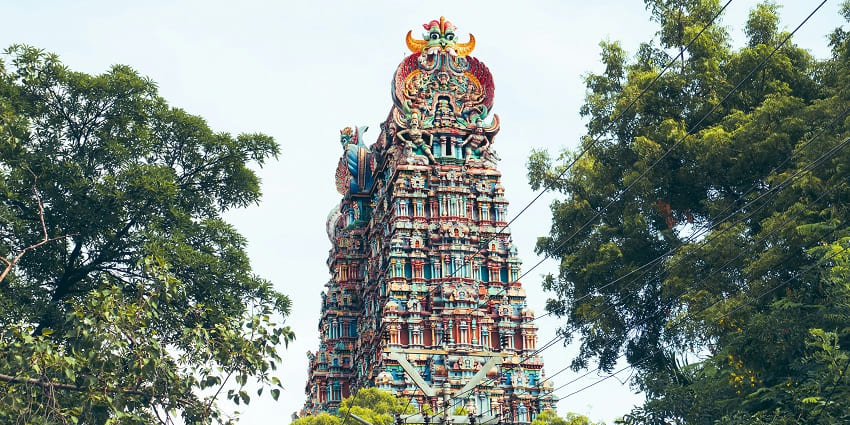 A photo of the West Tower of Meenakshi Amman Temple, showcasing vibrant sculptures.