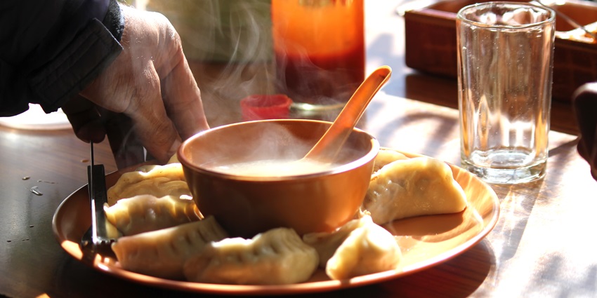 An image of steamed momo served with a side of comforting soup, a famous dish.