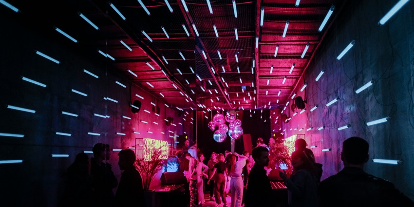 An inside view of the Monkey Valley featuring glistening lights and people partying.