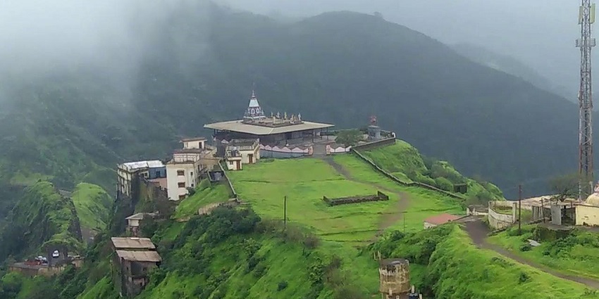 An aerial picture of a grassland with a temple on top of it.