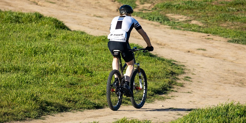 A picture of mountain bikers racing downhill through a scenic trail of the hills around Mumbai, typifying the adventure spirit involved.