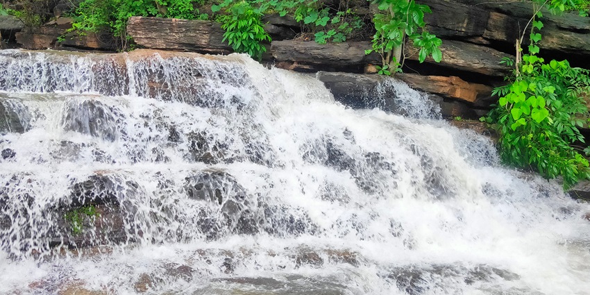 Flowing Muktai Waterfall, surrounded by rocks and greenery, a spot for camping near Nagpur.
