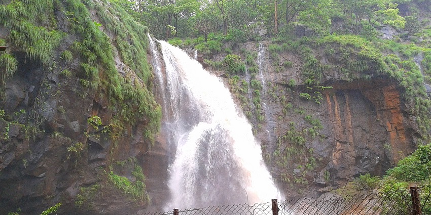 Muktai Waterfall is a picturesque waterfall cascading over rocky terrain amidst lush greenery.